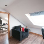 loft conversion, mirror and black chair positioned in open plan room with sky liner windows