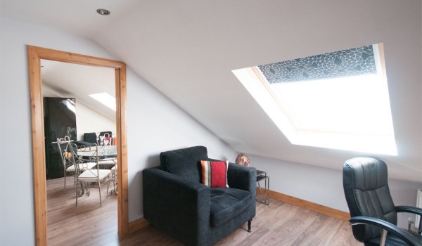 loft conversion, mirror and black chair positioned in open plan room with sky liner windows