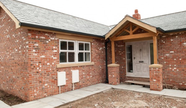 A red and white bricked house extension with wooden beams and windows