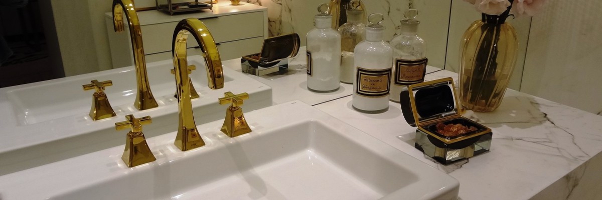 A picture of a sink unit with large gold mirror in an en-suite, one of many great design ideas for a loft conversion