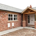 A red and white bricked house extension with wooden beams and windows